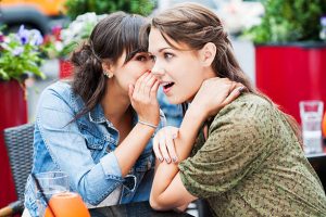 Two young women gossiping in a cafe